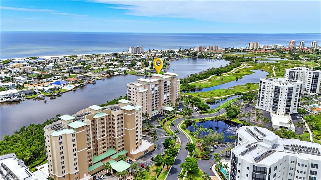 View of urban area featuring apartment complex and a large body of water - Virtually Edited Image