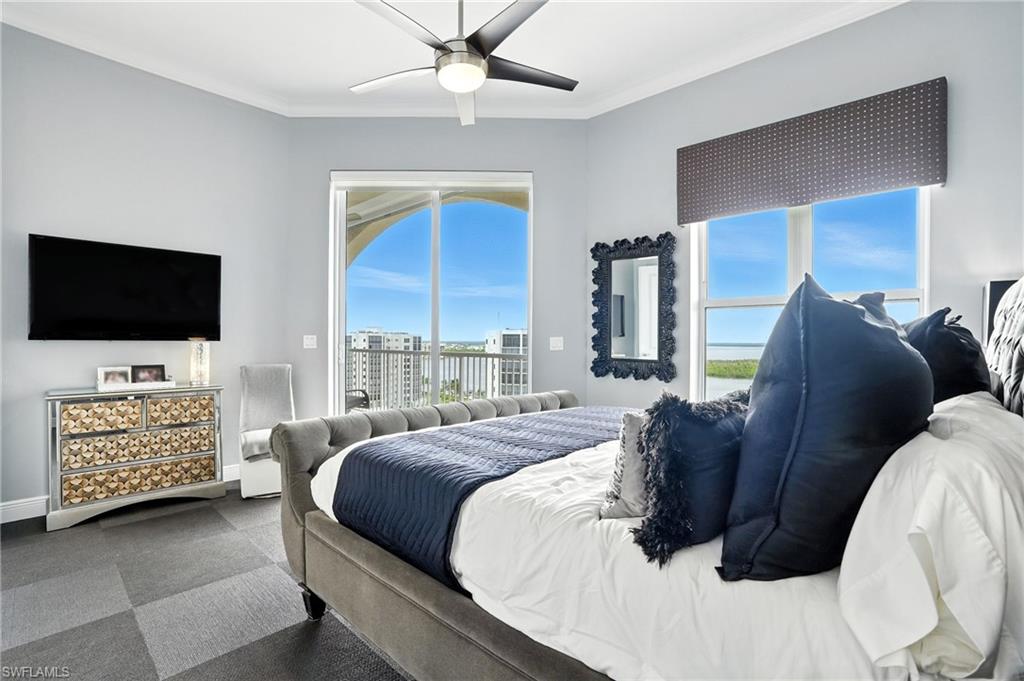 Bedroom with a ceiling fan, crown molding, access to exterior, and dark carpet - Virtually Edited Image