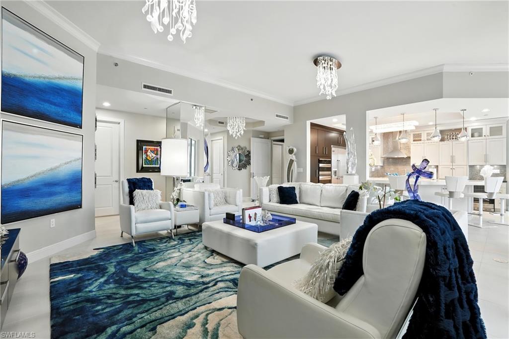 Living room with a chandelier, crown molding, recessed lighting, and light tile patterned flooring - Virtually Edited Image