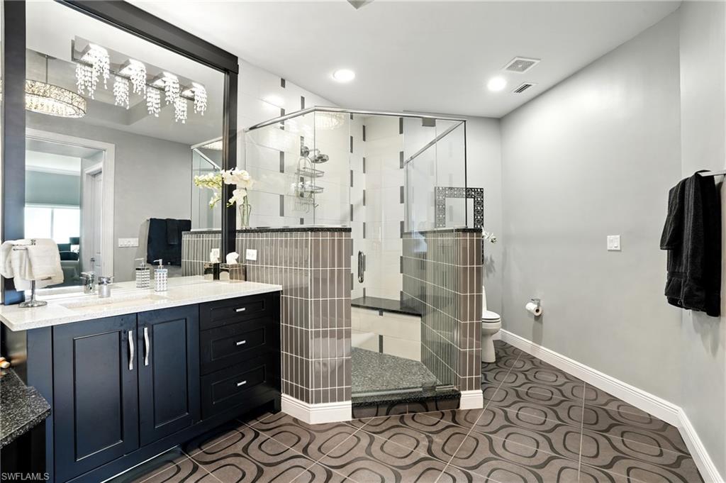 Full bathroom featuring vanity, a shower stall, dark tile patterned floors, and recessed lighting - Virtually Edited Image