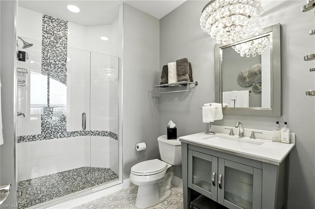 Full bath featuring a stall shower, vanity, a chandelier, light tile patterned floors, and recessed lighting - Virtually Edited Image