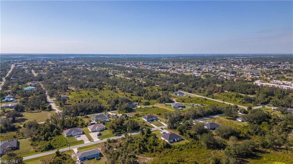 Aerial view of property and surrounding area with nearby suburban area