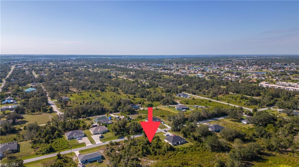 Aerial view of property and surrounding area with nearby suburban area