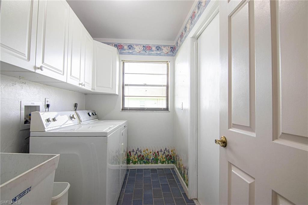 Laundry features full size laundry tub, washer, dryer, storage cabinets, great natural lighting and the garage entrance!