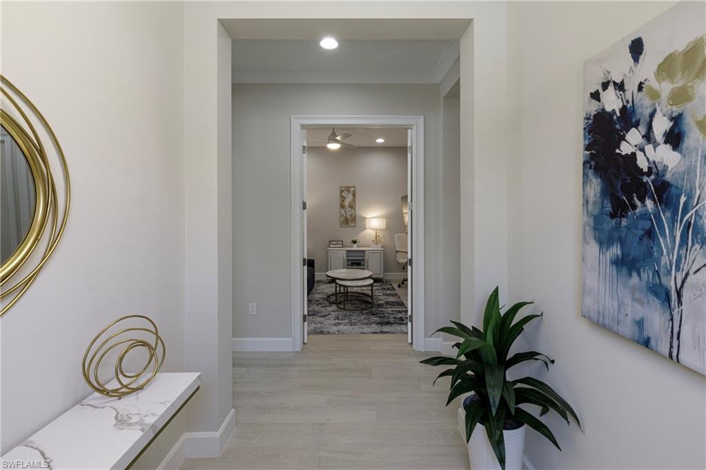 Corridor with light wood-type flooring and recessed lighting