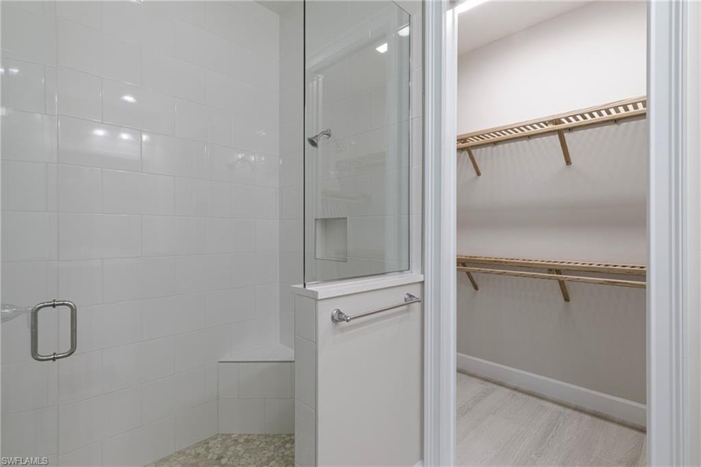 Full bath with a spacious closet and a walk in shower