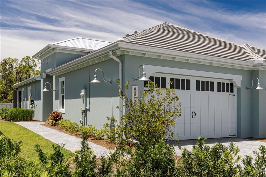 View of home's exterior featuring an attached garage, stucco siding, and a tile roof