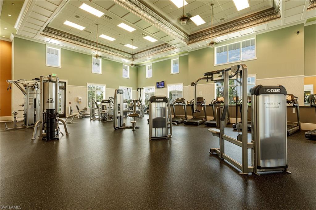 Workout area with a towering ceiling and ornamental molding