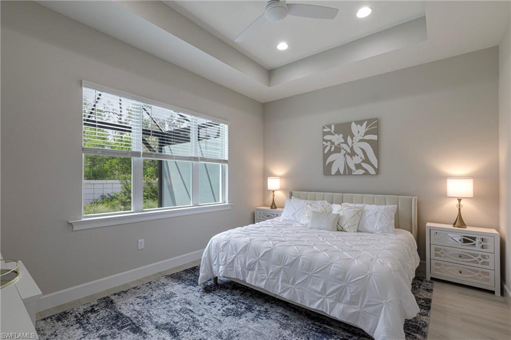 Bedroom featuring a raised ceiling, a ceiling fan, and recessed lighting