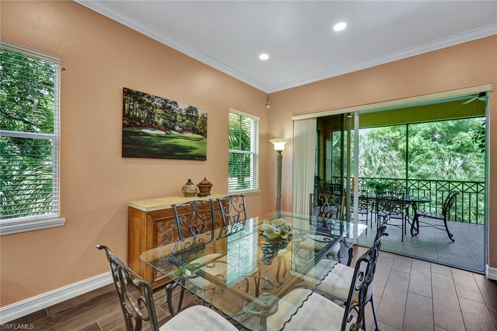 Dining room featuring wood tiled floors, ornamental molding, and recessed lighting