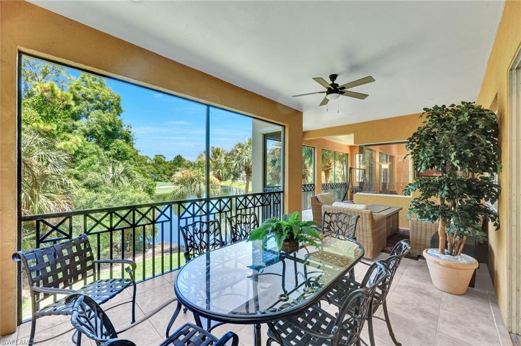 Sunroom / solarium with view of wooded area and tile patterned floors