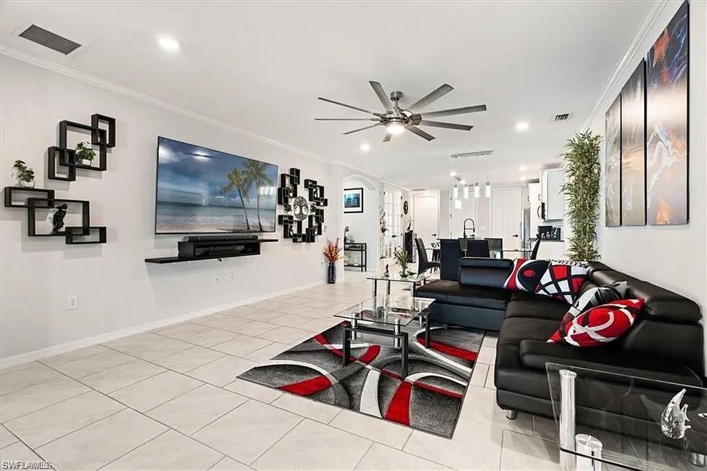 Living room with ornamental molding, light tile patterned floors, ceiling fan, and recessed lighting