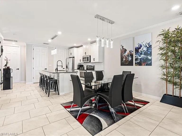 Dining space featuring recessed lighting, light tile patterned floors, and ornamental molding