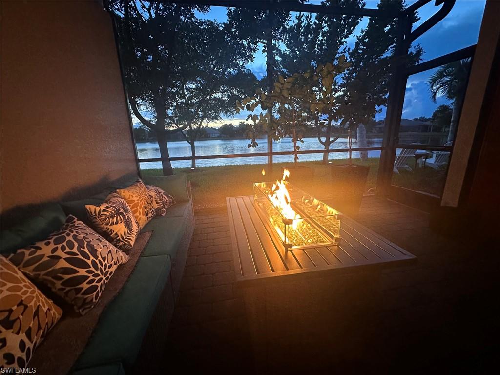 Deck with a water view, a fire pit, and a sunroom