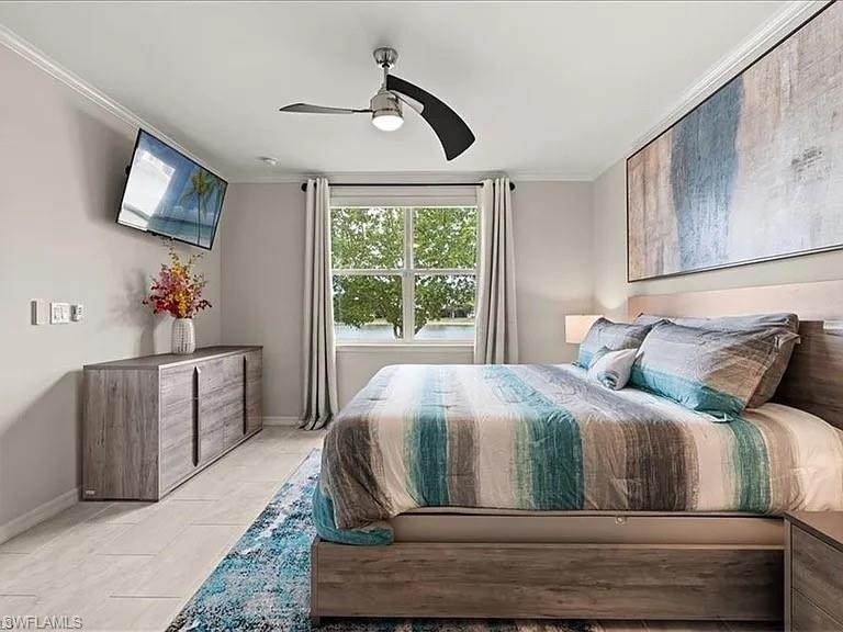 Bedroom featuring ornamental molding, a ceiling fan, and light tile patterned floors