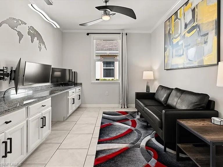 Living area with crown molding, light tile patterned floors, and a ceiling fan