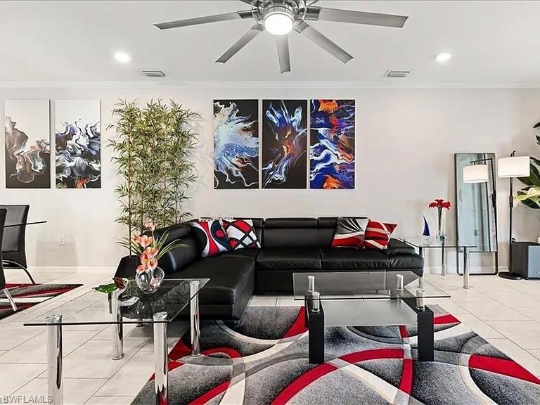 Tiled living room featuring crown molding, recessed lighting, and a ceiling fan