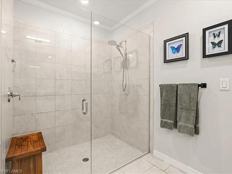 Bathroom with a shower stall, tile patterned floors, and ornamental molding
