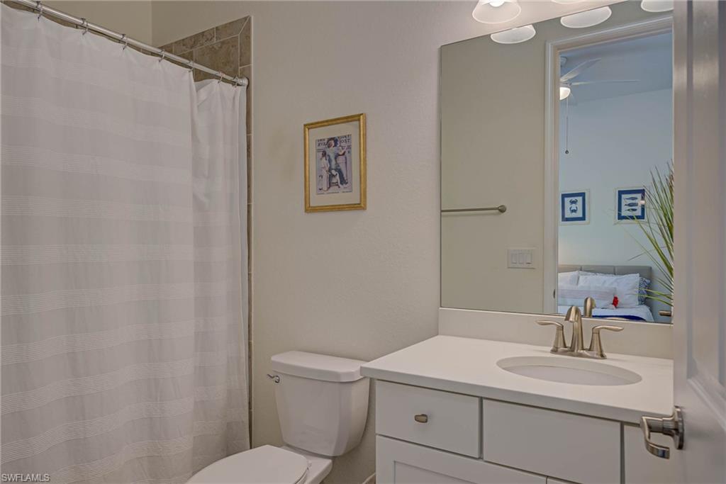 Full bath with vanity, a shower with curtain, and a ceiling fan