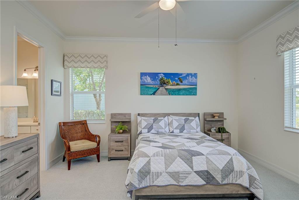 Bedroom with crown molding, light carpet, ensuite bath, and ceiling fan