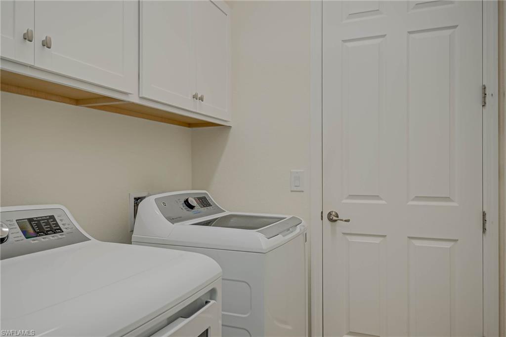 Washroom featuring cabinet space and independent washer and dryer