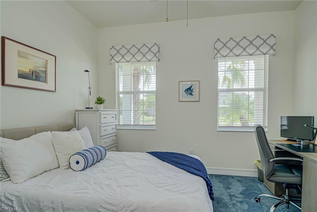 Bedroom with baseboards and an office area