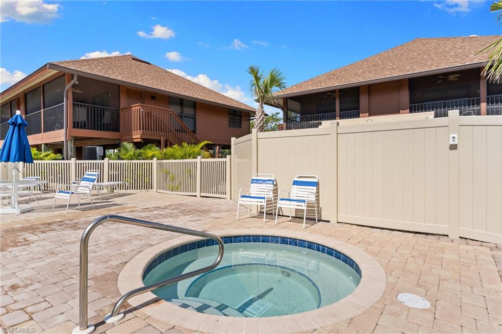 View of pool with a community hot tub, a sunroom, a patio area, and a ceiling fan