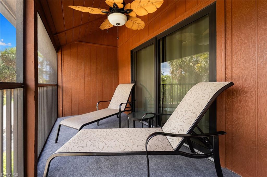 Sunroom / solarium featuring healthy amount of natural light, ceiling fan, a balcony, and lofted ceiling