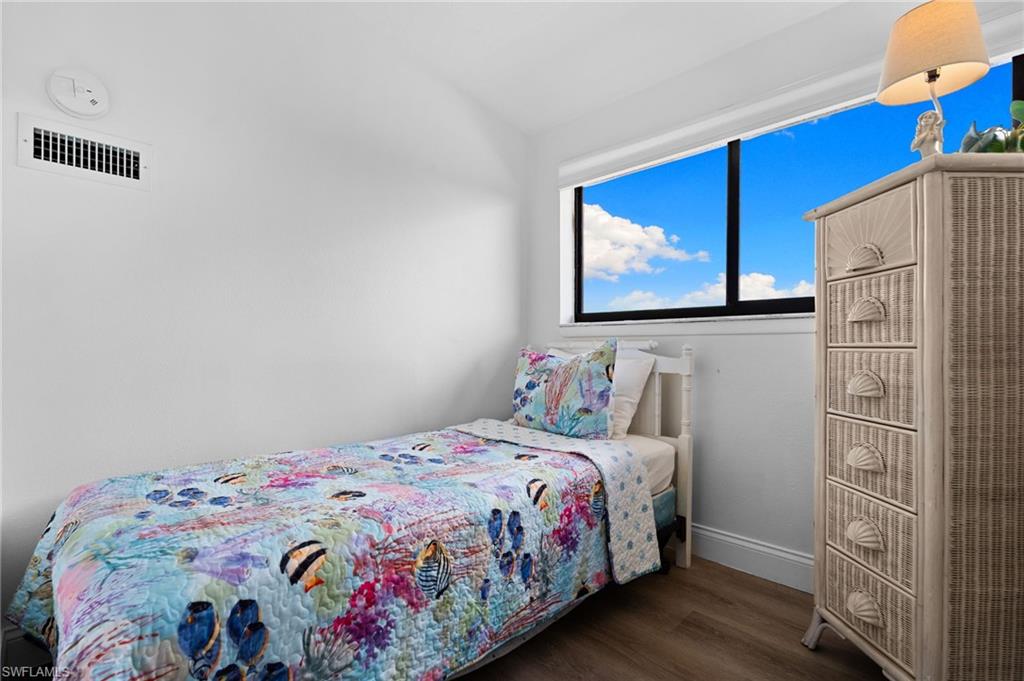 Bedroom featuring dark wood-style floors and baseboards