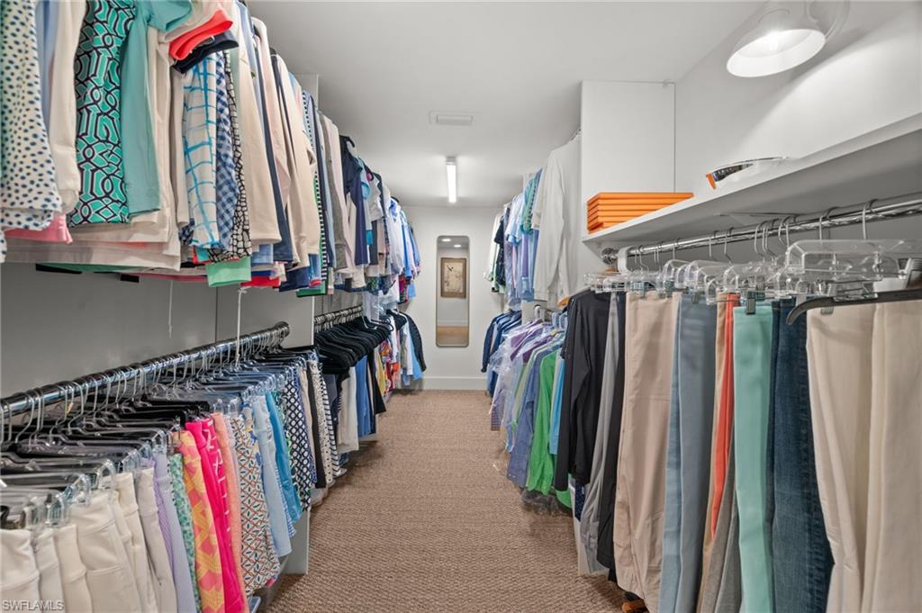 A walk-in primary closet has a terrific amount of  hanging space!