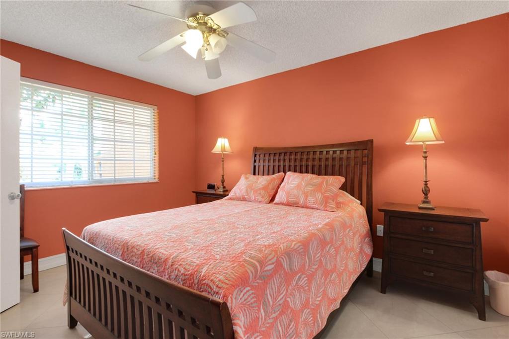Bedroom with light tile patterned floors, a textured ceiling, and a ceiling fan