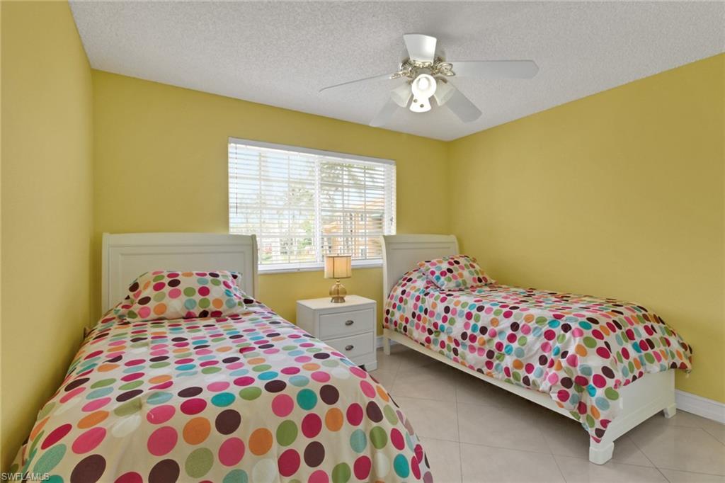 Bedroom featuring light tile patterned floors, a textured ceiling, and ceiling fan