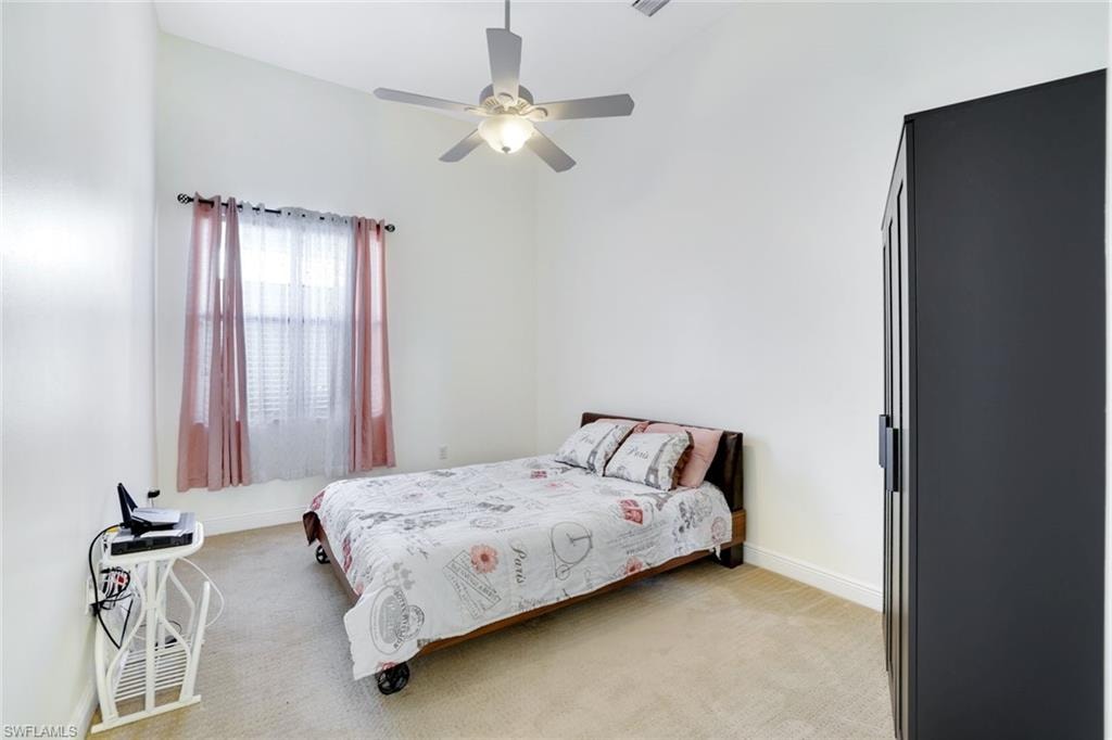 Bedroom featuring light carpet and a ceiling fan