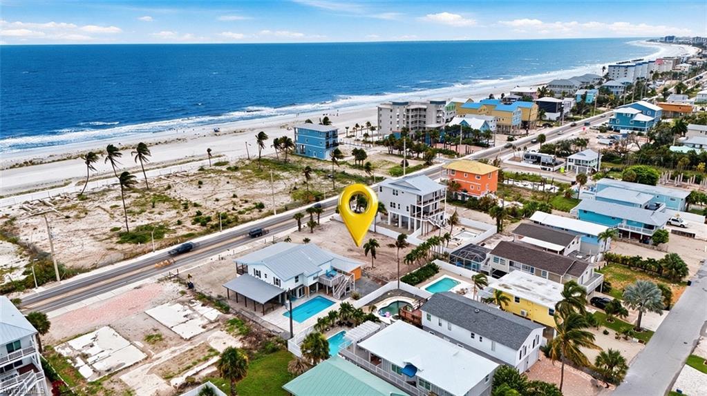 VIRTUALLY ENHANCED - Coastal property featuring a primary residence with a private swimming pool, an elevated main living level, and covered parking beneath