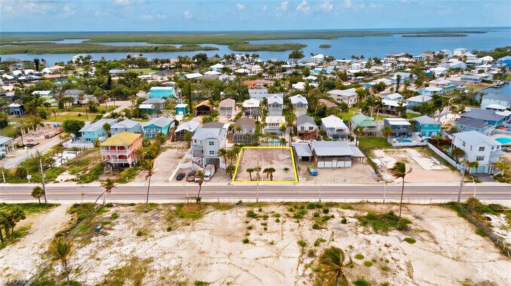 VIRTUALLY ENHANCED - Vacant lot featuring existing palm trees and direct road frontage