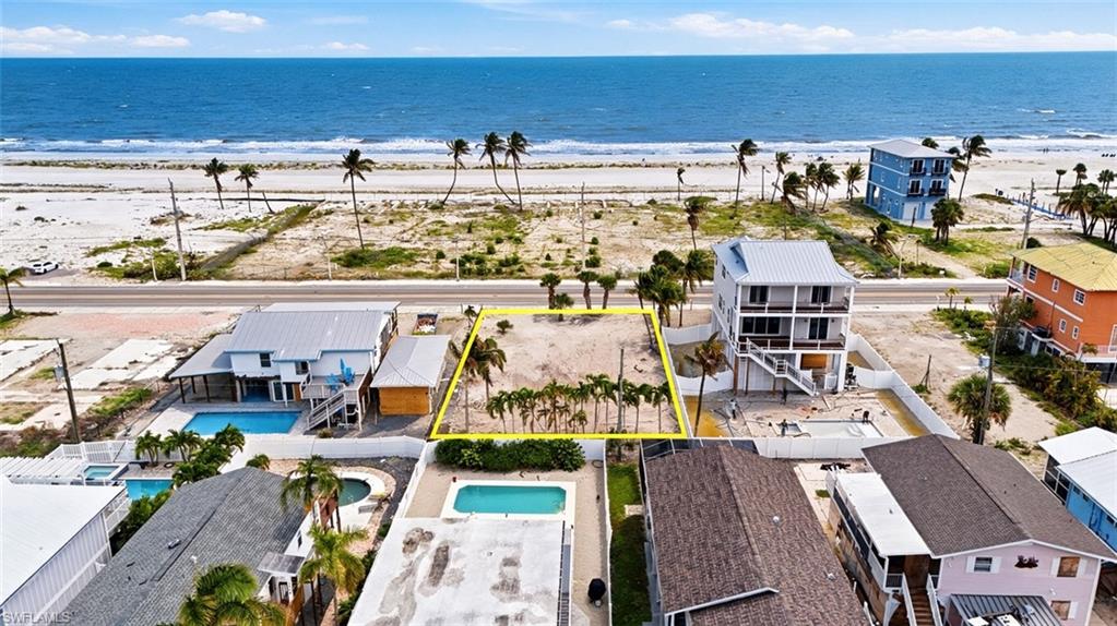 VIRTUALLY ENHANCED - Expansive land parcel with direct beach access, mature palm trees, and ocean frontage