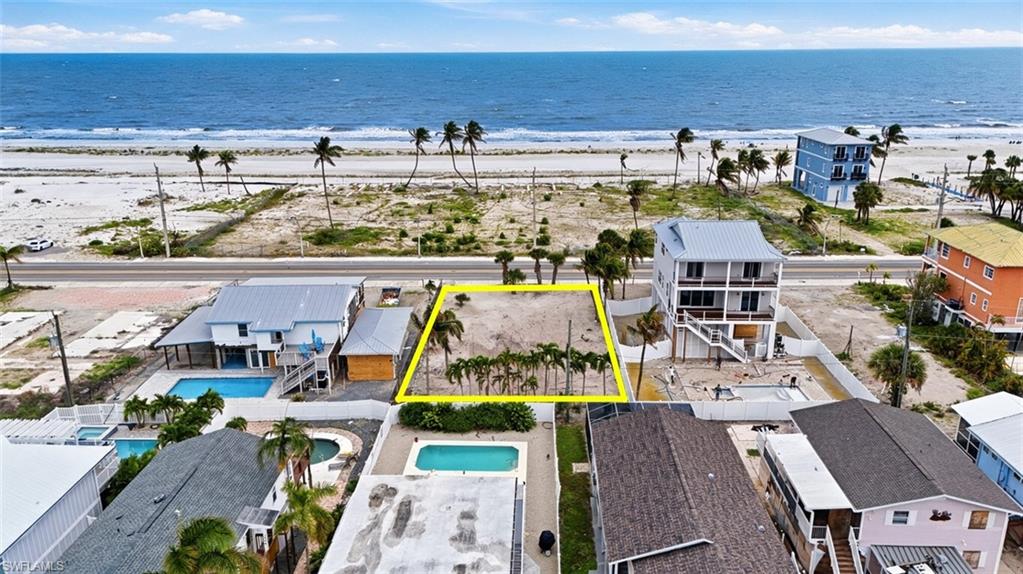 VIRTUALLY ENHANCED - Beachfront lot featuring direct access to the sand, mature palm trees, and ocean frontage