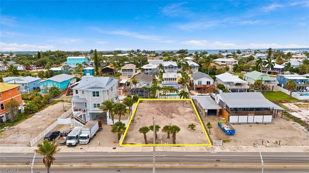 VIRTUALLY ENHANCED - Level building lot with street frontage, mature palm trees, and coastal proximity