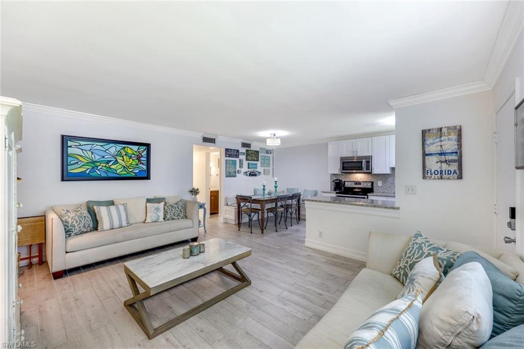 Living area featuring crown molding and light wood-style floors