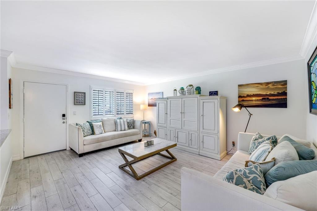 Living area with crown molding and light wood-type flooring