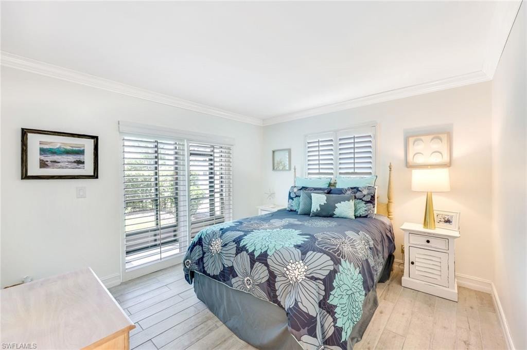 Bedroom with crown molding, access to outside, and hardwood / wood-style floors