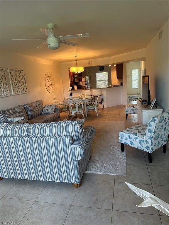 Living room featuring ceiling fan and tile patterned flooring