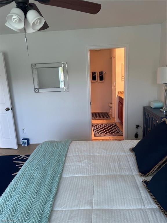 Tiled bedroom featuring ceiling fan and connected bathroom