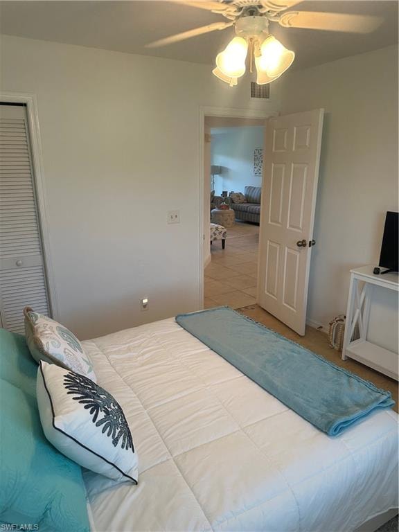 Bedroom featuring tile patterned floors, a closet, and ceiling fan