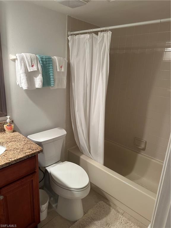Full bathroom with toilet, shower / tub combo with curtain, vanity, and tile patterned floors