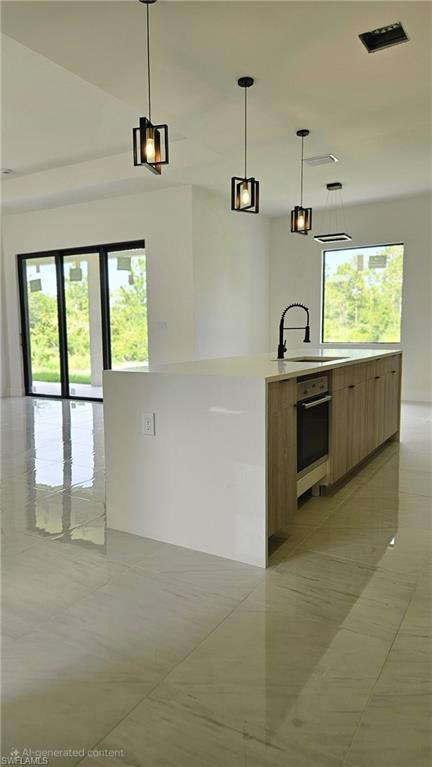 Kitchen featuring hanging light fixtures, light tile patterned floors, light stone counters, and open floor plan