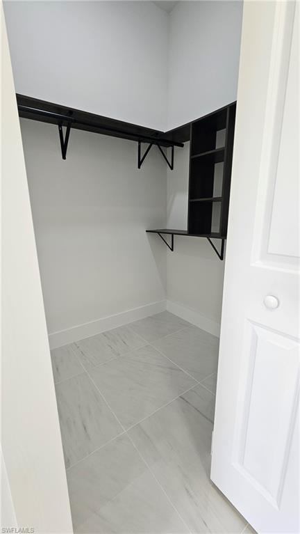 Spacious closet with light tile patterned floors