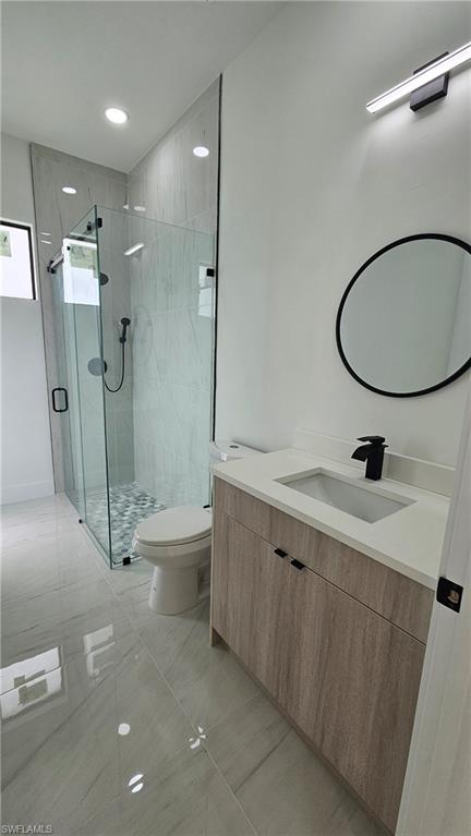 Bathroom featuring vanity, a stall shower, and recessed lighting