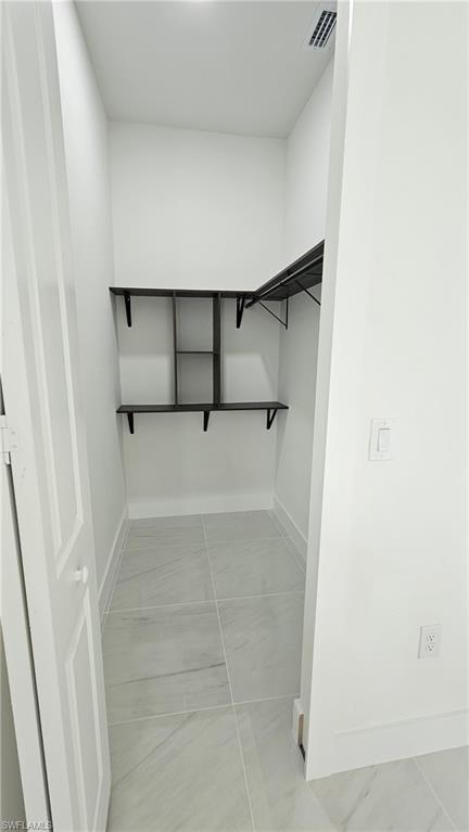 Spacious closet featuring light tile patterned floors