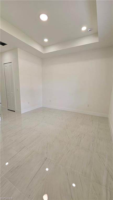 Unfurnished room featuring recessed lighting and a raised ceiling